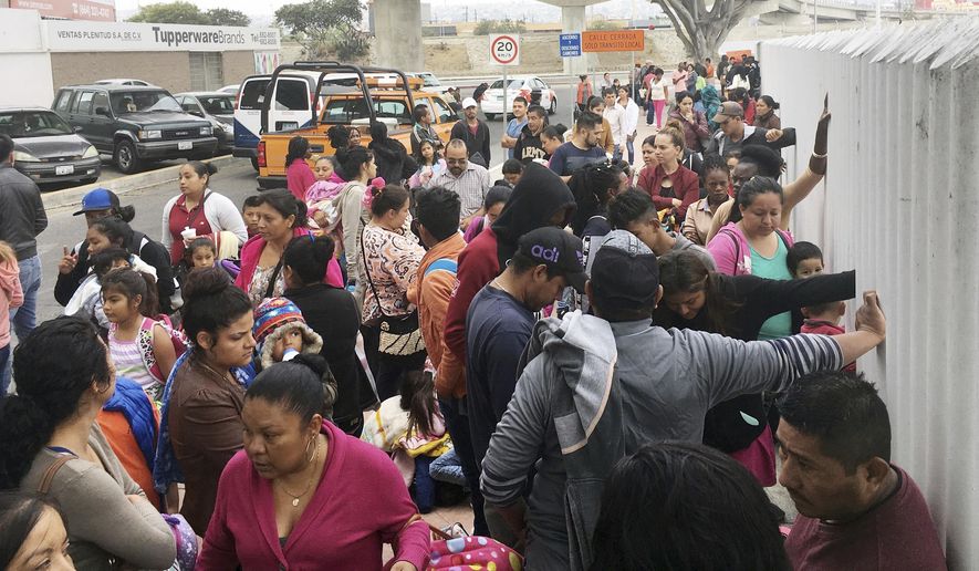 FILE - In this Monday, June 4, 2018 file photo, people seeking political asylum in the United States line up to be interviewed in Tijuana, Mexico, just across the U.S. border south of San Diego. Immigration judges generally cannot consider domestic and gang violence as grounds for asylum, U.S. Attorney General Jeff Sessions said Monday, June 11, 2018 in a ruling that could affect large numbers of Central Americans who have increasingly turned to the United States for protection. (AP Photo/Elliot Spagat, File)