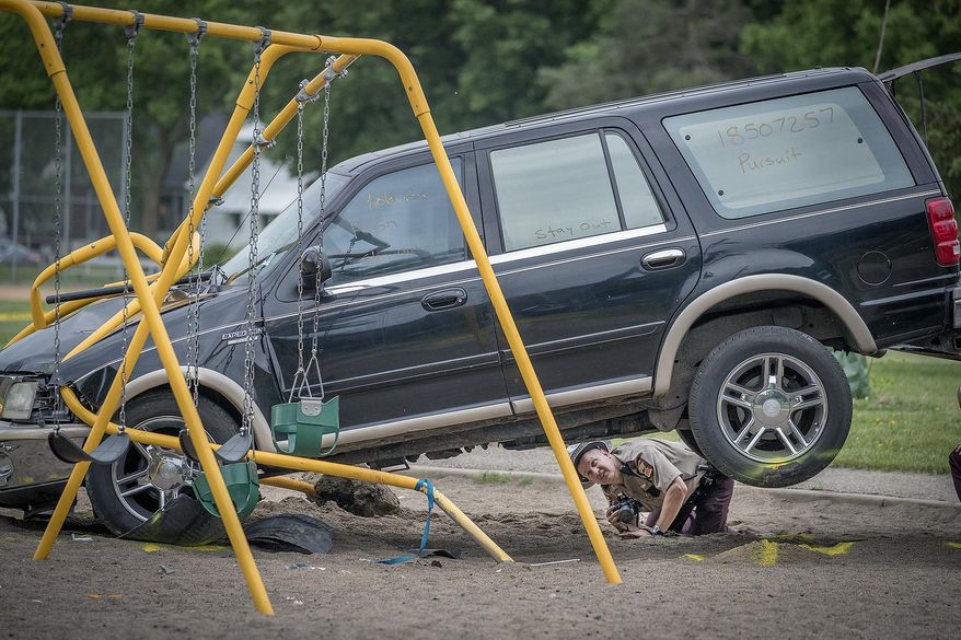 Minnesota State Patrol investigates the scene where a motorist being pursued by the State Patrol veered into a Minneapolis school playground Monday, June 11, 2018. At least two young children suffered life-threatening injuries after police say a motorist being pursued by the State Patrol veered into a Minneapolis park and struck them. The State Patrol says the driver ran from the crash scene and was arrested. (Elizabeth Flores/Star Tribune via AP)