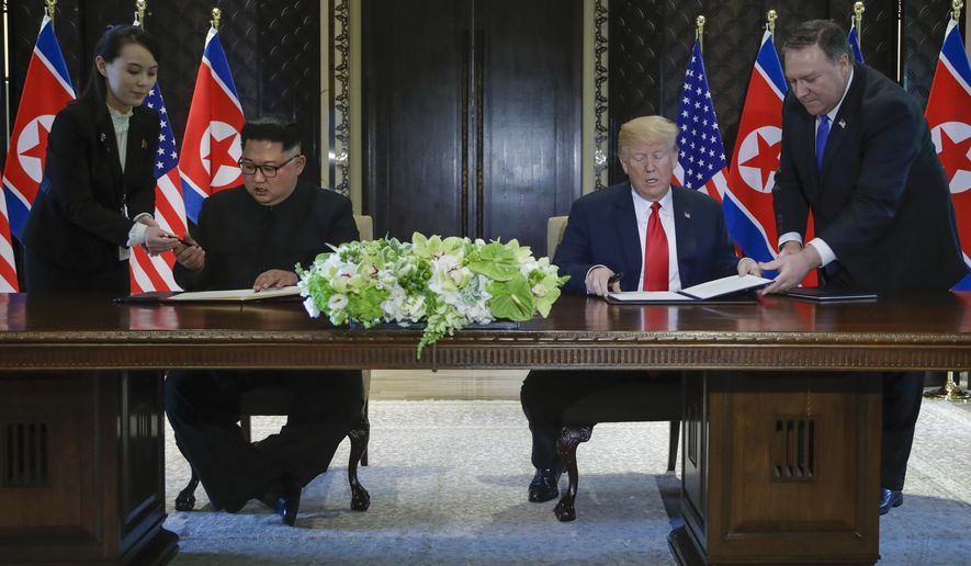 North Korea leader Kim Jong Un and U.S. President Donald Trump prepare to sign a document at the Capella resort on Sentosa Island Tuesday, June 12, 2018 in Singapore. (AP Photo/Evan Vucci)