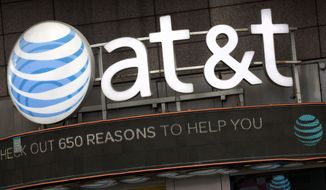 FILE - In this Monday, Oct. 24, 2016, file photo, the AT&amp;amp;T logo is positioned above one of its retail stores, in New York.  The fate of the AT&amp;amp;T-Time Warner merger, a massive media deal opposed by the government that could shape how much consumers pay for streaming TV and movies, rests in the hands of a federal judge.  U.S. District Judge Richard Leon is expected to announce in court Tuesday, June 12, 2018  his decision in the biggest antitrust trial in years.  (AP Photo/Mark Lennihan, File)