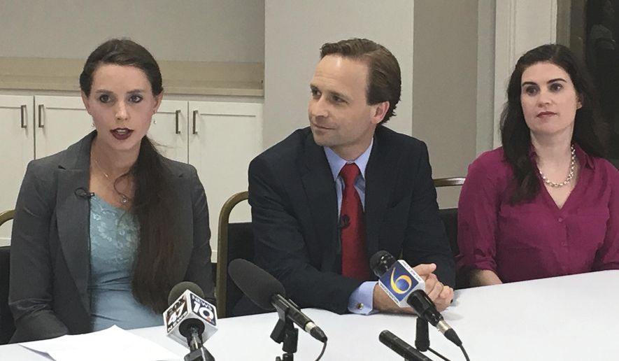 Rachael Denhollander, left, and Larissa Boyce, victims of imprisoned former sports doctor Larry Nassar, are joined by Michigan Lt. Gov. Brian Calley, center, at a news conference on Tuesday, June 12, 2018, in Lansing, Mich. Calley on Tuesday signed two bills inspired by the Nassar scandal, including one giving childhood sexual abuse victims more time to sue. (AP Photo/David Eggert)