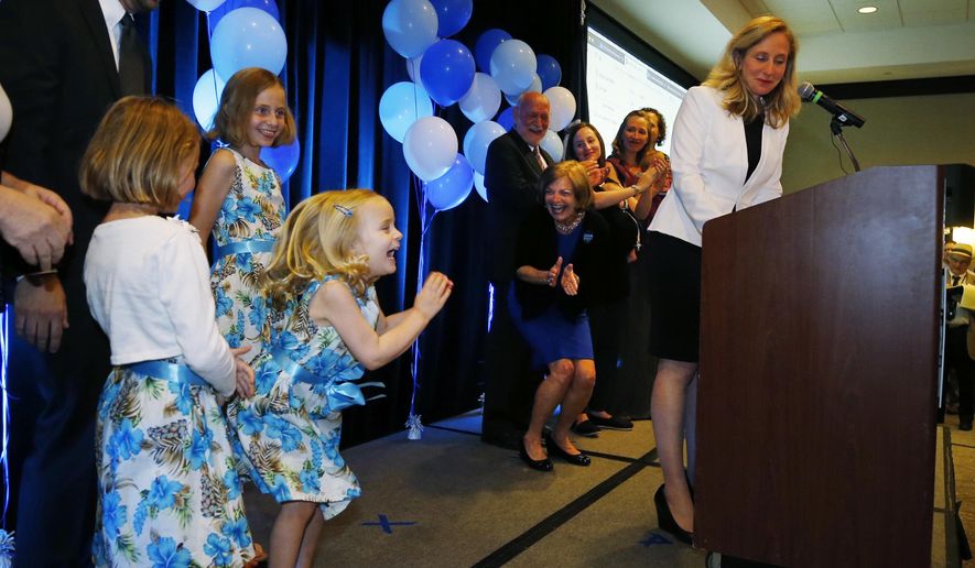 Daughter Catherine jumps for joy as Abigail Spanberger, Virginia's 7th District Democratic primary candidate, accepts the nomination on Tuesday June 12, 2018 at The Westin in Richmond, Va..At left is husband, Adam. She will face incumbent Dave Brat in November. (Joe Mahoney/Richmond Times-Dispatch via AP)