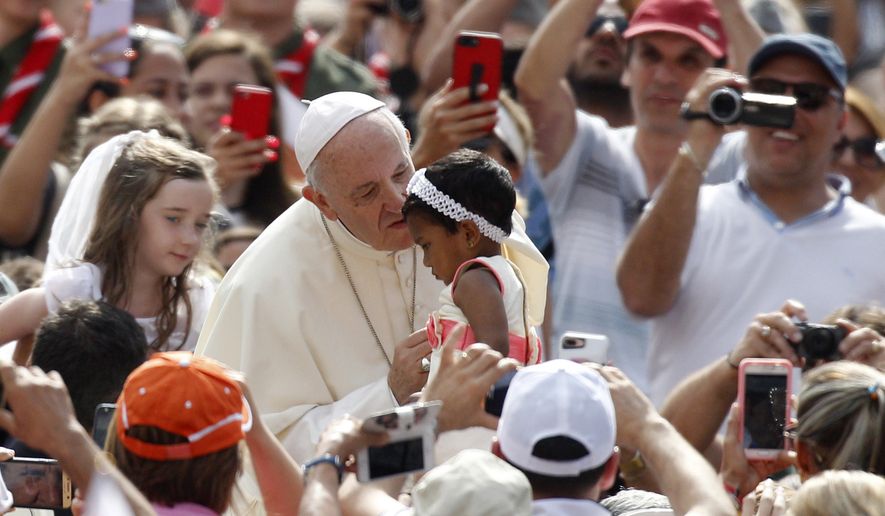 Pope Francis kisses a child as he arrives to attend his weekly general audience, in St. Peter&#39;s Square, at the Vatican, Wednesday, June 13, 2018. (AP Photo/Riccardo De Luca)