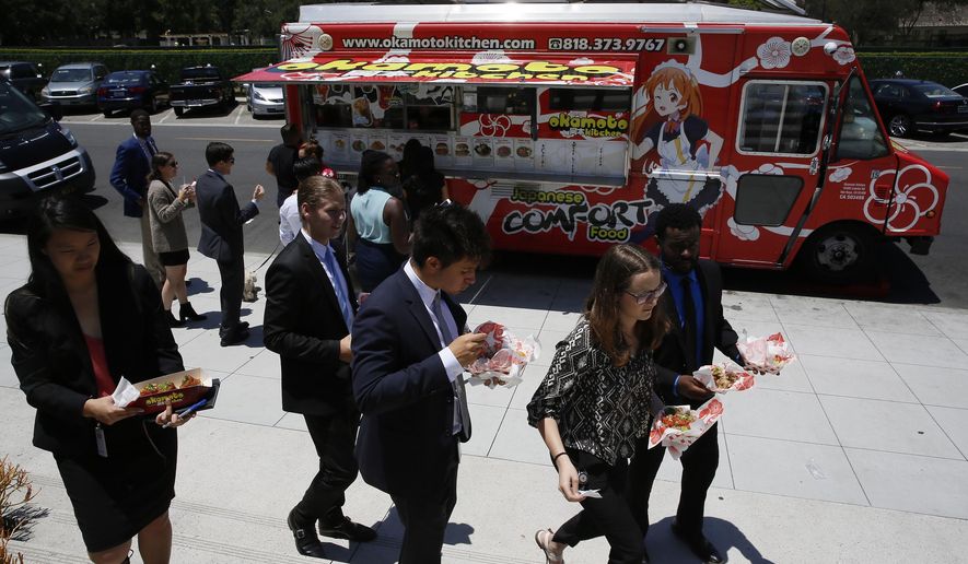 In this Friday, June 8, 2018, photo customers get their lunch at the Japanese food truck Okamoto Kitchen in Beverly Hills, Calif. Rather than sushi and tempura, they serve meat, fish and sandwiches using traditional Japanese flavors like ponzu. (AP Photo/Damian Dovarganes)