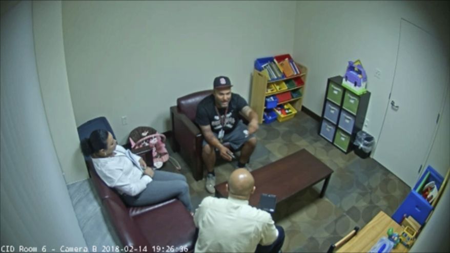 In this Feb. 14, 2018 frame from surveillance video provided by the Broward Sheriff's Office, Andrew Medina, center, is interviewed by detectives following the shooting at Marjory Stoneman Douglas High School in Florida. Medina, a baseball coach and unarmed campus monitor, told detectives he watched Nikolas Cruz get out of an Uber and head straight to the building where 17 people would be killed moments later at the school. (Broward Sheriff's Office via AP)