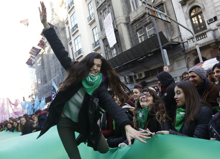 Women celebrate the approval of a bill legalizing abortion by the lower house of congress, in Buenos Aires, Thursday, June 14, 2018. The lower house of Argentina's congress has approved a bill that would legalize elective abortion in the first 14 weeks of pregnancy, sending the measure to the Senate. President Mauricio Macri has said he'll sign the bill if it's approved. (AP Photo/Jorge Saenz)