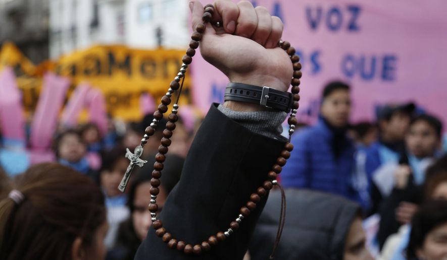 Pro-life protesters rally against a proposed law to legalize abortion, with one holding a Catholic rosary, near Congress in Buenos Aires, Wednesday, June 13, 2018. Argentina's legislature has begun debating a measure that would allow elective abortions in the first 14 weeks of gestation. (AP Photo/Jorge Saenz)
