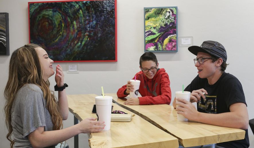 In a June 7, 2018 photo, Laurna Chapman, Landon Pinnock, with hat, and JR Chapman have sodas at The Drink Factory in Idaho Falls, Idaho. Soda shops, also known as soda shacks, have become a mainstay in the region. (John Roark/The Idaho Post-Register via AP)