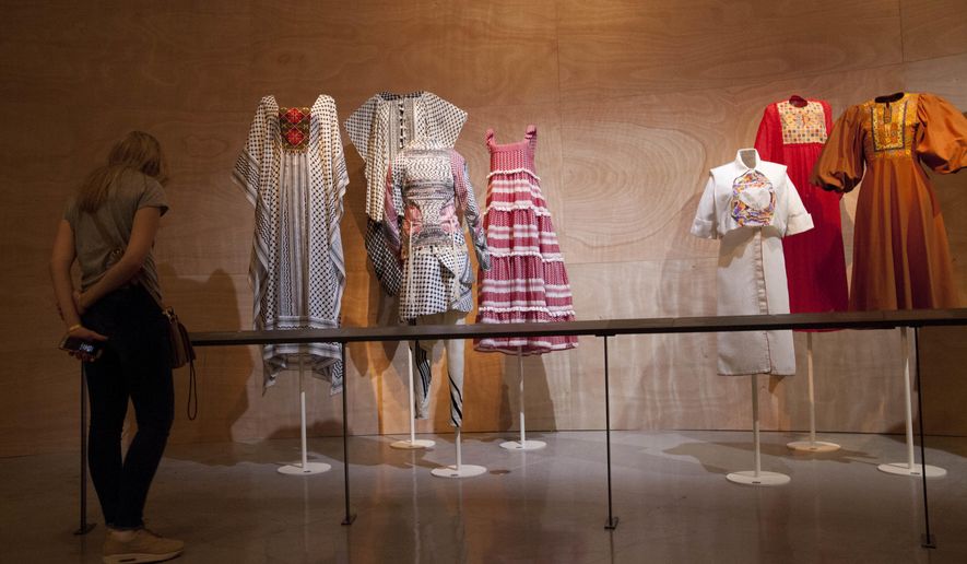 A woman looks at "Fashion Statements: Decoding Israeli Dress" exhibition at Israel Museum in Jerusalem, Thursday, June 14, 2018. (AP Photo/Caron Creighton)
