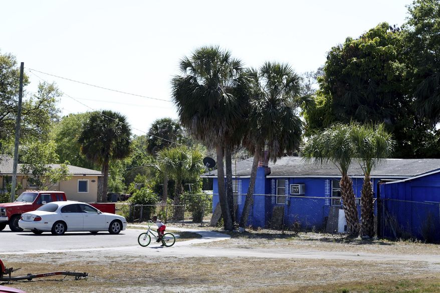 This photo taken March 18, 2018, shows a boy riding a bicycle in the Dansville, Fla., neighborhood, a 68 acre residential area located just north of Ulmerton Road and west of Ridge Road in unincorporated Pinellas County. It is part of a larger African-American community referred to as the Baskins/Dansville/Ridgecrest communities which is comprised of 481 acres. The Dansville neighborhood is primarily residential, with single-family houses, several commercial uses, three churches and a community center. (Douglas R. Clifford/The Tampa Bay Times via AP)