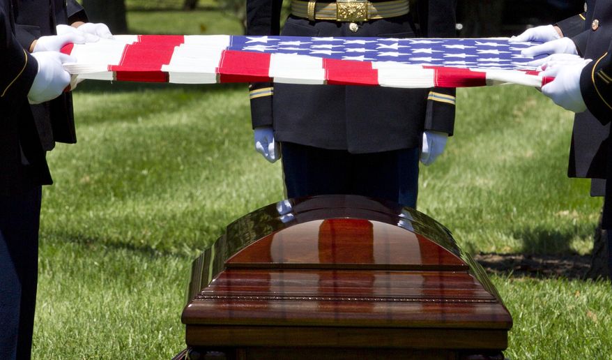 An Army team holds a U.S. flag over the casket of U.S. Army Air Forces 2nd Lt. Robert R. Keown during a burial service at Arlington National Cemetery in Arlington, Va., on Friday, June 15, 2018. Keown was piloting his P-38 aircraft when it crashed in Papua New Guinea in 1944. (AP Photo/Jose Luis Magana)