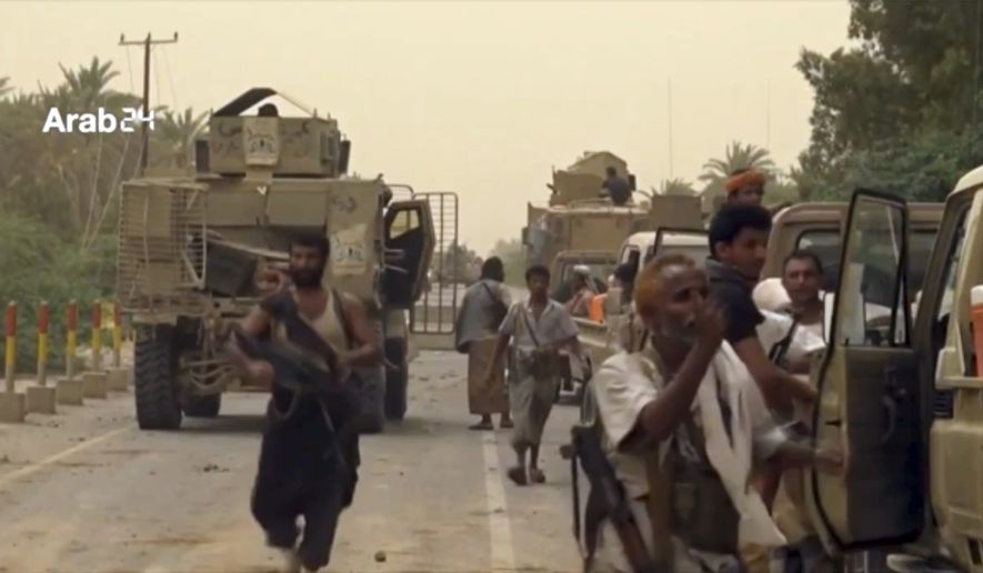 This still image taken from video provided by Arab 24 shows Saudi-led forces gathering to retake the international airport of Yemen's rebel-held port city of Hodeida from the Shiite Houthi rebels Saturday, June 16, 2018. With battles raging at the southern side of al-Hodeida International Airport, the military of Yemen's exiled government said it had entirely seized the facility, and that engineers were working to clear mines from nearby areas just south of the city of some 600,000 people on the Red Sea. (Arab 24 via AP)