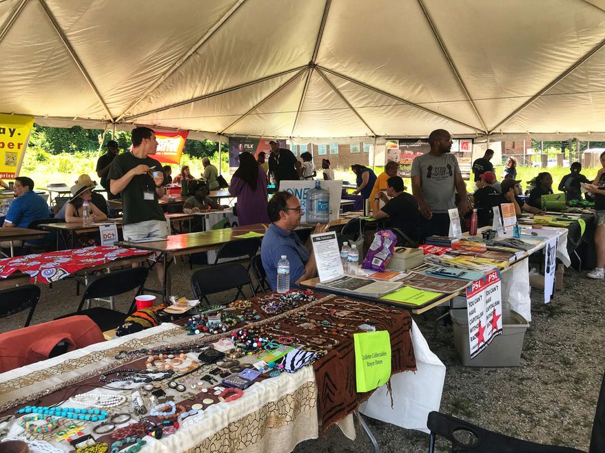 Vendors gather Saturday under a festival tent on the 2500 block of Martin Luther King Avenue SE to raise awareness about Juneteenth, community-building and faith organizations in D.C. (Darla Dunning / The Washington Times)