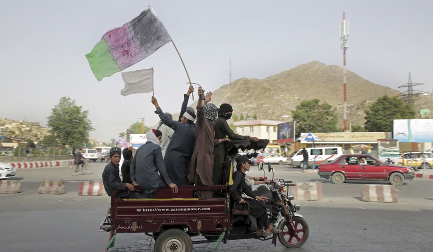 Taliban fighters and their supporters carry a representation of the Afghan national flag and a Taliban flag while riding in a motorized vehicle, in Kabul, Afghanistan, Sunday, June 17, 2018. A suicide bomber struck Sunday in Afghanistan&#39;s eastern city of Jalalabad, killing at least 18 people in the second attack in as many days targeting Taliban fighters, security forces and civilians celebrating a holiday cease-fire. (AP Photo/Massoud Hossaini)