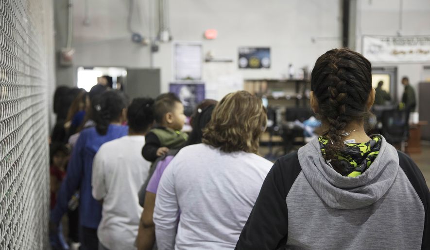 In this photo provided by U.S. Customs and Border Protection, people who&#x27;ve been taken into custody related to cases of illegal entry into the United States, stand in line at a facility in McAllen, Texas, Sunday, June 17, 2018. (U.S. Customs and Border Protection&#x27;s Rio Grande Valley Sector via AP)