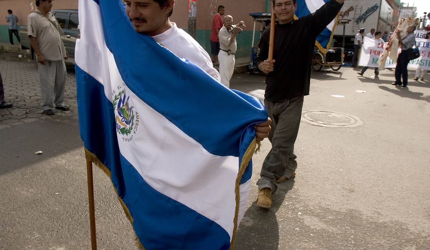 Central American migrants carry a flags of El Salvador and Honduras during a celebration of National Migrant Day at the Suchiate River on the border of Guatemala and Mexico on Sunday Sep. 3, 2006. (AP Photo/Moises Castillo)