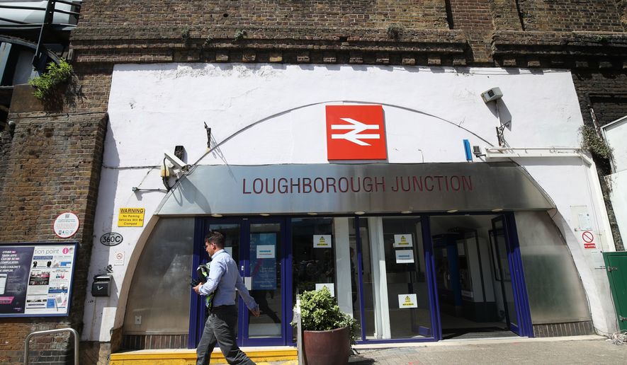 A man walks past Loughborough Junction railway station in south London, Monday June 18, 2018. British Transport Police say three people have died after being struck by a train in south London. Details about the deaths are not yet clear. (Yui Mok/PA via AP)