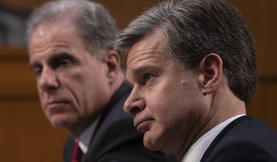 FBI Director Christopher Wray, with Justice Department Inspector General Michael Horowitz, left, testifies as the Senate Judiciary Committee examines the internal report of the FBI's Clinton email probe and the role of former FBI Director James Comey's actions during the 2016 presidential campaign, on Capitol Hill in Washington, Monday, June 18, 2018. (AP Photo/J. Scott Applewhite)