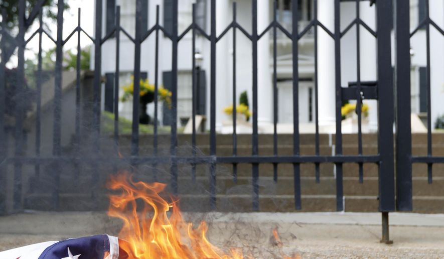 Remnants of a Mississippi state flag burn in front of the Governor's Mansion after members of the Mississippi Poor People's Campaign burned it and a Confederate battle flag in protest in Jackson, Miss., Monday, June 18, 2018. The campaign, held the last of its weekly protests in Jackson, joining a nationwide effort that called for lawmakers and statewide elected officials to address the need for union rights, living wages, fully funded anti-poverty programs and properly fund public education. (AP Photo/Rogelio V. Solis)
