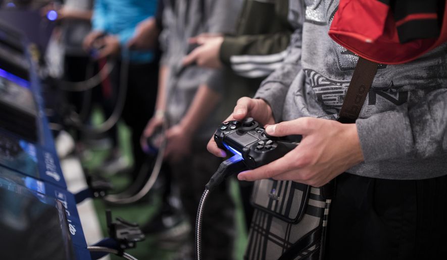 In this Friday, Nov. 3, 2017, file photo, a man plays a game at the Paris Games Week in Paris. The World Health Organization says that compulsively playing video games now qualifies as a new mental health condition, in a move that some critics warn may risk stigmatizing its young players. (AP Photo/Kamil Zihnioglu, File)