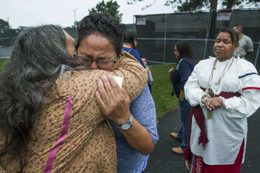 FILE - In this Monday, Aug. 7, 2017 file photo, Millie Friday, a descendent of Little Plume, a Native American student who was taken from his family and forced to go to boarding school, is comforted by Barbara Andrews-Christy of Circle Legacy Center, as Aílice Hall looks during a gathering on the grounds of the Carlisle Barracks, in Carlisle, Pa. The forced separation of Latino migrant children from their parents has generated strong condemnation of President Trump&#x27;s immigration policies but it&#x27;s not the first time the U.S. government or authorities have been involved in separating children from their families. (Charles Fox/The Philadelphia Inquirer via AP, File)