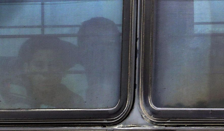 A boy stares out of a heavily tinted bus window leaving a U.S. Customs and Border Protection facility, Tuesday, June 19, 2018, in McAllen, Texas. More than 2,300 minors have been separated from their families crossing the border to the U.S. under a zero-tolerance policy where everyone caught crossing illegally is prosecuted. (AP Photo/Eric Gay)