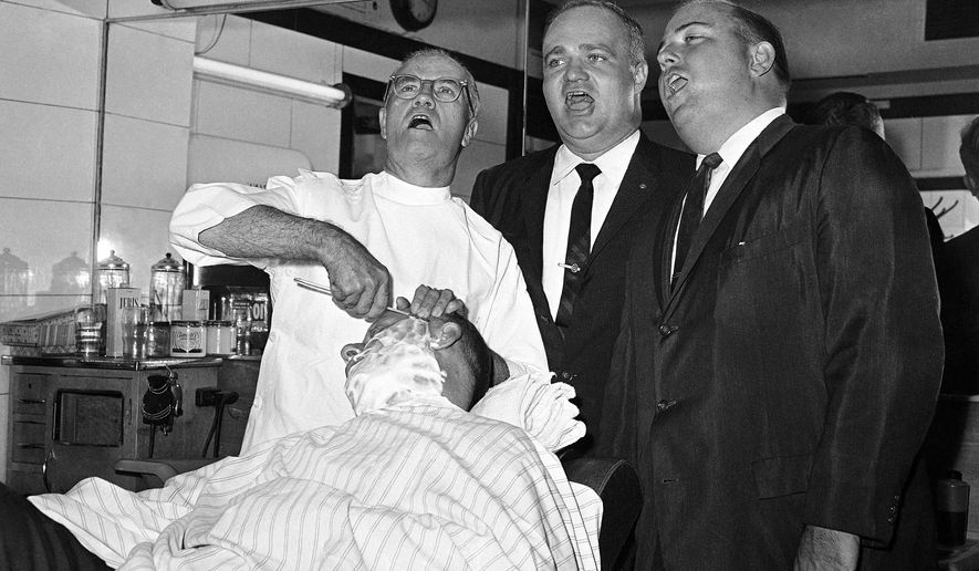 FILE - In this Sept. 30, 1961 file photo, three members of the Sentiment-Gentlemen Quartet, standing from left, barber Ancel Cochran, florist Jack Goza and insurance salesman George Roth sing in an Atlanta barber shop while Abner Cohen receives a shave. After 80 years of being a male-only organization, the Barbershop Harmony Society announced Wednesday that women will be allowed to join the a Capella singing organization.The organization, which is based in Nashville, Tennessee, said in a statement on its website that membership to the society is open to everyone, effective immediately. (AP Photo, File)
