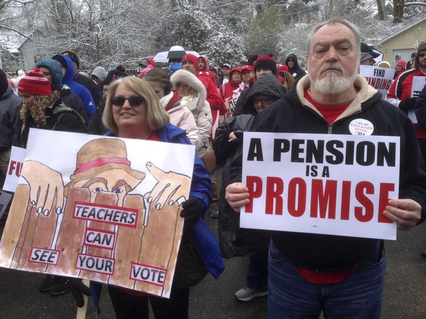 FILE - In a March 21, 2018 file photo, Debbie Burke, left, an elementary school teacher in Pike County, and her husband Gary Burke rally against a proposed pension overhaul bill, in Frankfort, Ky. Franklin County, Ky., Circuit Judge Phillip Shepherd on Wednesday, June 20, 2018 ruled that the process the Republican-led legislature used to enact the law violated the state Constitution. (AP Photo/Bruce Schreiner, File)