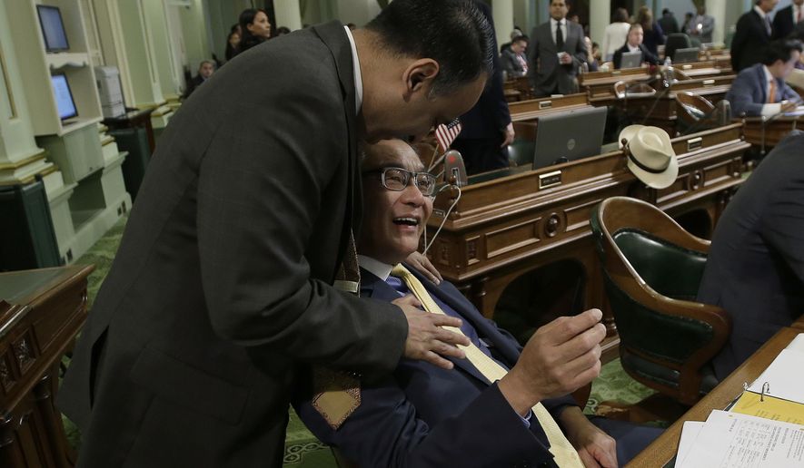 Assemblyman Kansen Chu, D-San Jose, right, receives congratulation from Assemblyman Ash Kalra, D-San Jose, after his bill that ask voters to take an initial step toward changing the states daylight savings policy was approved by the Assembly. (AP Photo/Rich Pedroncelli)