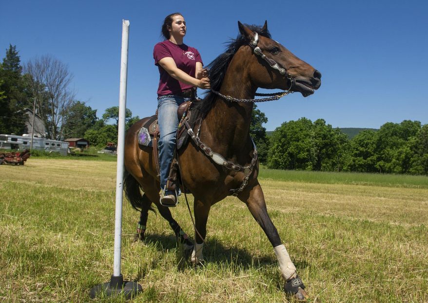Jeni Fey, of Hegins, rides her horse Charlie through poles as she practices for the 70th Annual National High School Finals Rodeo pole bending competition on Tuesday, June 12, 2018 at her home in Hegins, Pa. (David McKeown/The Republican-Herald via AP)