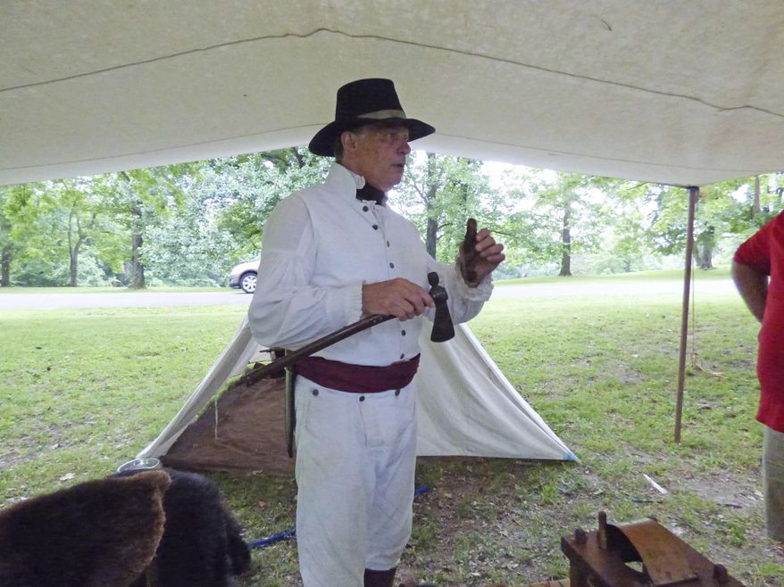 In this June 9, 2018 photo, Jan Donelson talks to visitors at Fort Kaskaskia State Historical Site, in Ellis Grove, Ill., while portraying Capt. Meriwether Lewis. Donelson is part of the Lewis and Clark Discovery Expedition, a group of re-enactors from St. Charles, Missouri. (Marilyn Halstead/The Southern, via AP)