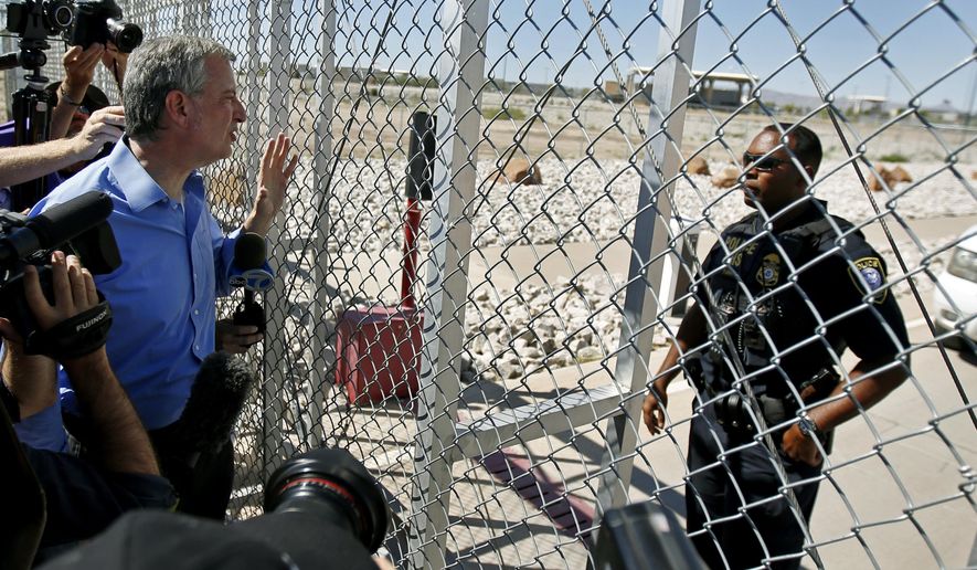 New York City Mayor Bill de Blasio, left, requests entrance to the holding facility for immigrant children in Tornillo, Texas, near the Mexican border, Thursday, June 21, 2018. About 20 mayors from cities across the country are calling for the immediate reunification of immigrant children with their families. (AP Photo/Andres Leighton)