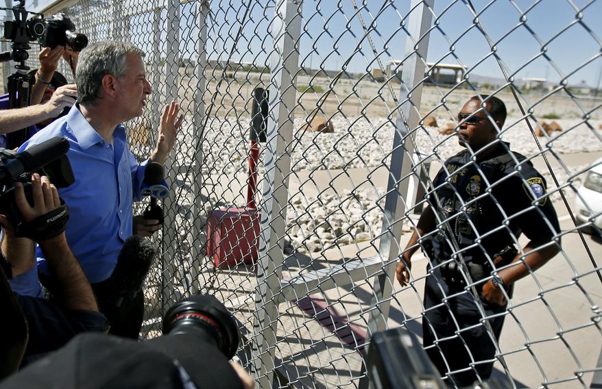 New York City Mayor Bill de Blasio, left, requests entrance to the holding facility for immigrant children in Tornillo, Texas, near the Mexican border, Thursday, June 21, 2018. About 20 mayors from cities across the country are calling for the immediate reunification of immigrant children with their families. (AP Photo/Andres Leighton)