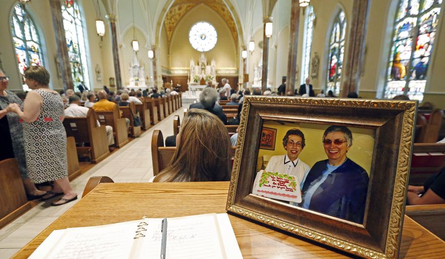 FILE - In this Aug. 29, 2016, file photo, a photograph showing Sisters Margaret Held, left, of the School Sisters of St. Francis, and Paula Merrill, of the Sisters of Charity of Nazareth, sits at the entrance to the Cathedral of St. Peter the Apostle in Jackson, Miss., where a memorial Mass was held fo ther two 68-year-old nuns, who were killed in their Durant home. District Attorney Akillie Malone-Oliver told The Associated Press Tuesday, June 12, 2018, that Robert Earl Sanders of Kosciusko, charged with killing the two nuns will plead guilty, Thursday, June 21, 2018, as part of an agreement that removes the possibility of the death penalty. (AP Photo/Rogelio V. Solis, File)