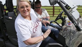 In this Thursday, June 14, 2018 photo, elementary school principal Sherrie Conley, left, who is running for state representative in District 20, gets out of a vehicle driven by friend Jana Robins, right, as she goes door-to-door campaigning in Goldsby, Okla, Thursday, June 14, 2018. Conley is part of a wave of about 100 educators, including dozens of Republicans, who are running for office in the aftermath of a teacher walk-out that shut down public schools for two weeks this spring and opened an unusually bitter chasm in the state’s ruling party. (AP Photo/Sue Ogrocki)
