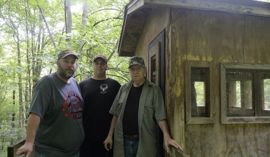 In this Monday, June 18, 2017 photo, three generations of hunters from left, Matt Howser, his son Taylor Howser, and father Vaughn Howser stand outside a tree stand, which Matt built for his his father after a rare muscle disease attributed to Agent Orange exposure in Vietnam,  on their family farm in Smock, Pa.  (Alyssa Choiniere /Herald-Standard via AP)