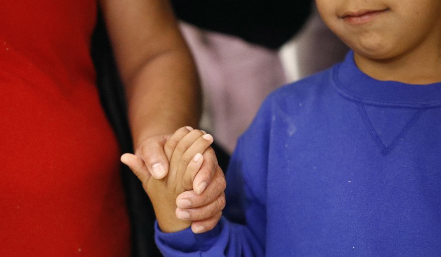 Darwin Micheal Mejia, right, holds hands with his mother, Beata Mariana de Jesus Mejia-Mejia, during a news conference following their reunion at Baltimore-Washington International Thurgood Marshall Airport, Friday, June 22, 2018, in Linthicum, Md. The Justice Department agreed to release Mejia-Mejia's son after she sued the U.S. government in order to be reunited following their separation at the U.S. border. She has filed for political asylum in the U.S. following a trek from Guatemala. (AP Photo/Patrick Semansky)