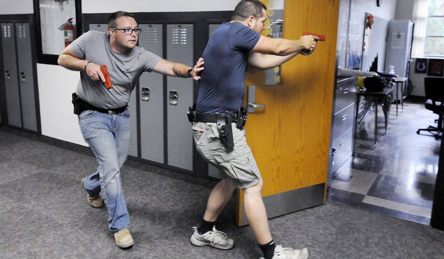 Justin Royse, left, and Dakota Steele practice moving down a hallway during active shooter training at Daleville High School in Daleville, Ind. on Saturday, June 23, 2018. The training included local officers and teachers from the school district. (Don Knight)/The Herald-Bulletin via AP)