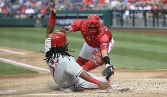 Philadelphia Phillies&#39; Maikel Franco, left, comes home to score against Washington Nationals catcher Spencer Kieboom, right, during the second inning of a baseball game, Saturday, June 23, 2018, in Washington. (AP Photo/Nick Wass)