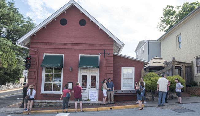 Passersby gather to take photos in front of the Red Hen Restaurant, Saturday, June 23, 2018, in Lexington, Va. White House press secretary Sarah Huckabee Sanders said Saturday in a tweet that she was booted from the Virginia restaurant because she works for President Donald Trump. Sanders said she was told by the owner of The Red Hen that she had to &quot;leave because I work for @POTUS and I politely left.&quot; (AP Photo/Daniel Lin)