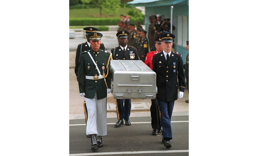 FILE- In this May 14, 1999, file photo, U.N. honor guards carry a coffin containing the remains of the American soldiers after it was returned from North Korea at the border village of Panmunjom, South Korea. South Korean media reported that the U.S. military plans to send 215 caskets to North Korea through a border village on Saturday, June 23, 2018, so that the North could begin the process of returning the remains of U.S. soldiers who have been missing since the 1950-53 Korean War. (AP Photo/Ahn Young-joon, File)