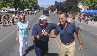 Mitt and Ann Romney are greeted by a supporter during the Strawberry Day Parade Saturday, June 23, 2018, in Pleasant Grove, Utah. Romney is flashing his familiar smile at city parks and backyards in Utah&#39;s mountains and suburbs this week, making his final pitch after being forced into a Republican primary against a conservative state lawmaker. At stake is being the party&#39;s representative to vie for the Senate seat long held by retiring Republican Sen. Orrin Hatch. (AP Photo/Rick Bowmer)