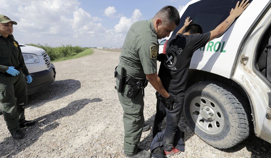 U.S. Border Patrol agent Rene Cisneros gives migrant Gerberht Caraac, from Guatemala, a pat-down after he was caught trying to illegally enter the United States, Monday, June 25, 2018, in Hidalgo, Texas. (AP Photo/David J. Phillip)