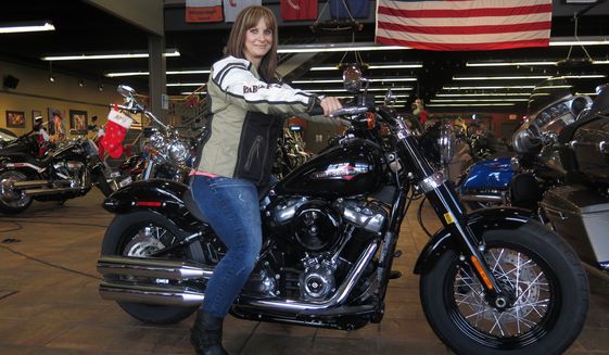 FILE - In this Dec. 12, 2017, file photo, Terri Meehan poses on a 2018 Harley Softail Slim in Milwaukee&#39;s House of Harley. Meehan took a riding course at the dealership as part of Harley-Davidson&#39;s &quot;Riding Academy,&quot; an initiative the company hopes will help bring new customers. Harley-Davidson, the iconic brand that sells its customers an image of freedom and adventure, found itself in an unwanted role this week: poster child for the damage of an international trade war. Harley said it would move production of motorcycles bound for Europe overseas, blaming European Union tariffs it said would add an estimated $2,200 cost to the average bike.(AP Photo/Ivan Moreno, File) **FILE**