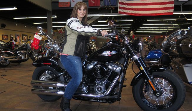 FILE - In this Dec. 12, 2017, file photo, Terri Meehan poses on a 2018 Harley Softail Slim in Milwaukee&#x27;s House of Harley. Meehan took a riding course at the dealership as part of Harley-Davidson&#x27;s &quot;Riding Academy,&quot; an initiative the company hopes will help bring new customers. Harley-Davidson, the iconic brand that sells its customers an image of freedom and adventure, found itself in an unwanted role this week: poster child for the damage of an international trade war. Harley said it would move production of motorcycles bound for Europe overseas, blaming European Union tariffs it said would add an estimated $2,200 cost to the average bike.(AP Photo/Ivan Moreno, File) **FILE**