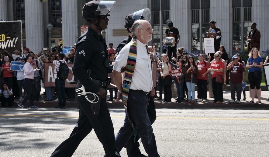 A member of a group of clergy is arrested during a civil disobedience protest in front of a federal courthouse in Los Angeles on Tuesday, June 26, 2018. Immigrant-rights advocates asked a federal judge to order the release of parents separated from their children at the border, as demonstrators decrying the Trump administration&#39;s immigration crackdown were arrested Tuesday at a rally ahead of a Los Angeles appearance by Attorney General Jeff Sessions. (AP Photo/Richard Vogel)