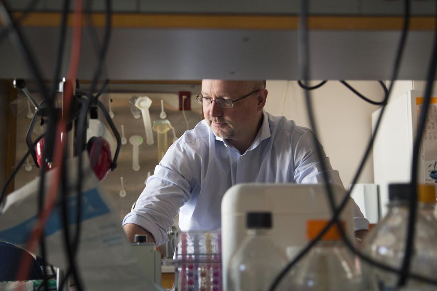 This Aug. 8, 2013 photo provided by Duke University shows Dr. Matthias Gromeier at his laboratory at Duke in Durham, N.C. Gromeier developed a modified poliovirus to attack glioblastoma brain tumor cells. One of the world's most dreaded viruses has been turned into an immune system therapy to fight deadly brain tumors. Survival was better than expected for patients in a small study treated with the modified poliovirus, which helped their bodies attack their cancer, doctors reported on Tuesday, June 26, 2018. (Shawn Rocco/Duke Health via AP)
