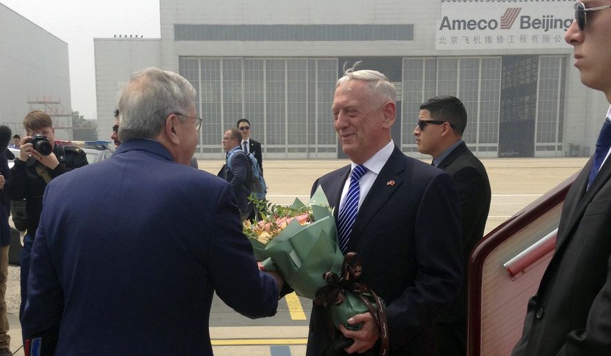 U.S. Defense Secretary Jim Mattis, center, is greeted as he arrives at Beijing Capital International Airport in Beijing, Tuesday, June 26, 2018. Mattis laid out plans for a less contentious, more open dialogue with Chinese leaders as he travels to Asia, less than a month after he slammed Beijing at an international conference for its militarization of islands in the South China Sea. (AP Photo/Lolita Baldor)