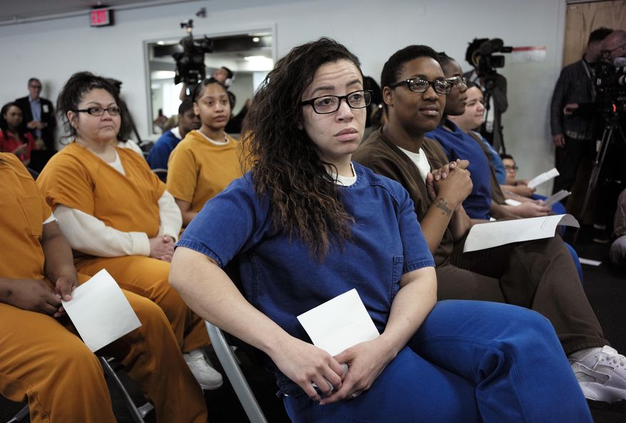 Ashley McSween, center, an inmate at Suffolk County House of Correction at South Bay, is seated with other inmates during a forum with six candidates for Suffolk County District Attorney, Tuesday, June 26, 2018, at the jail, in Boston. Some of the inmates in the audience, including McSween, presented questions to the candidates who hope to replace District Attorney Dan Conley, who announced in February he wouldn't seek re-election. (AP Photo/Steven Senne)