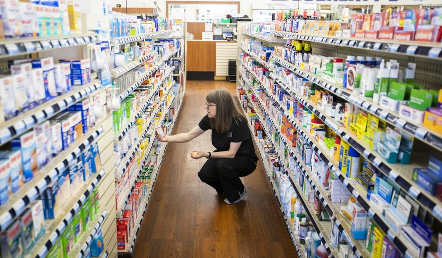 An employee works among the shelves of the flagship Dougherty&#39;s Pharmacy in Preston Royal Village on Thursday, May 31, 2018, in Dallas. (Smiley N. Pool/The Dallas Morning News via AP)